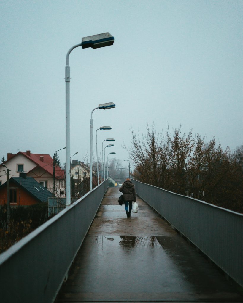 Woman walking alone over a footbridge